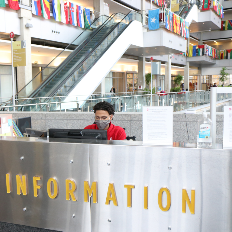 A student working at the information desk in the campus center.